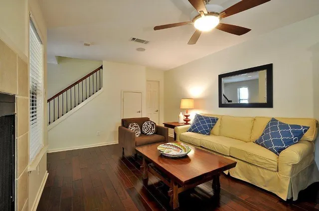 a living room with furniture and a wooden floor