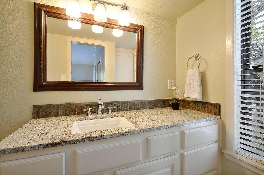 735 Patterson Avenue Austin, TX 78703 - Photo 9 of 15 a bathroom with a granite countertop sink and a mirror