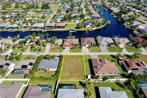 an aerial view of a swimming pool with outdoor seating and yard