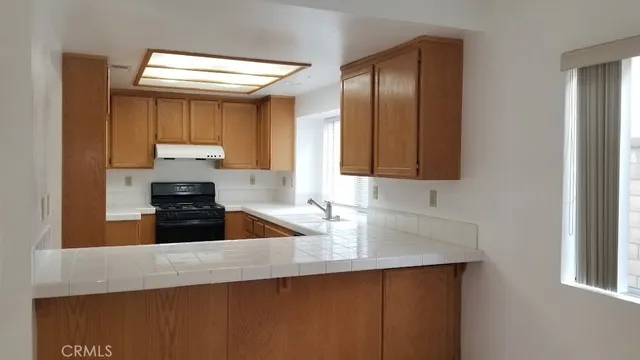 a kitchen with granite countertop a sink a stove and refrigerator