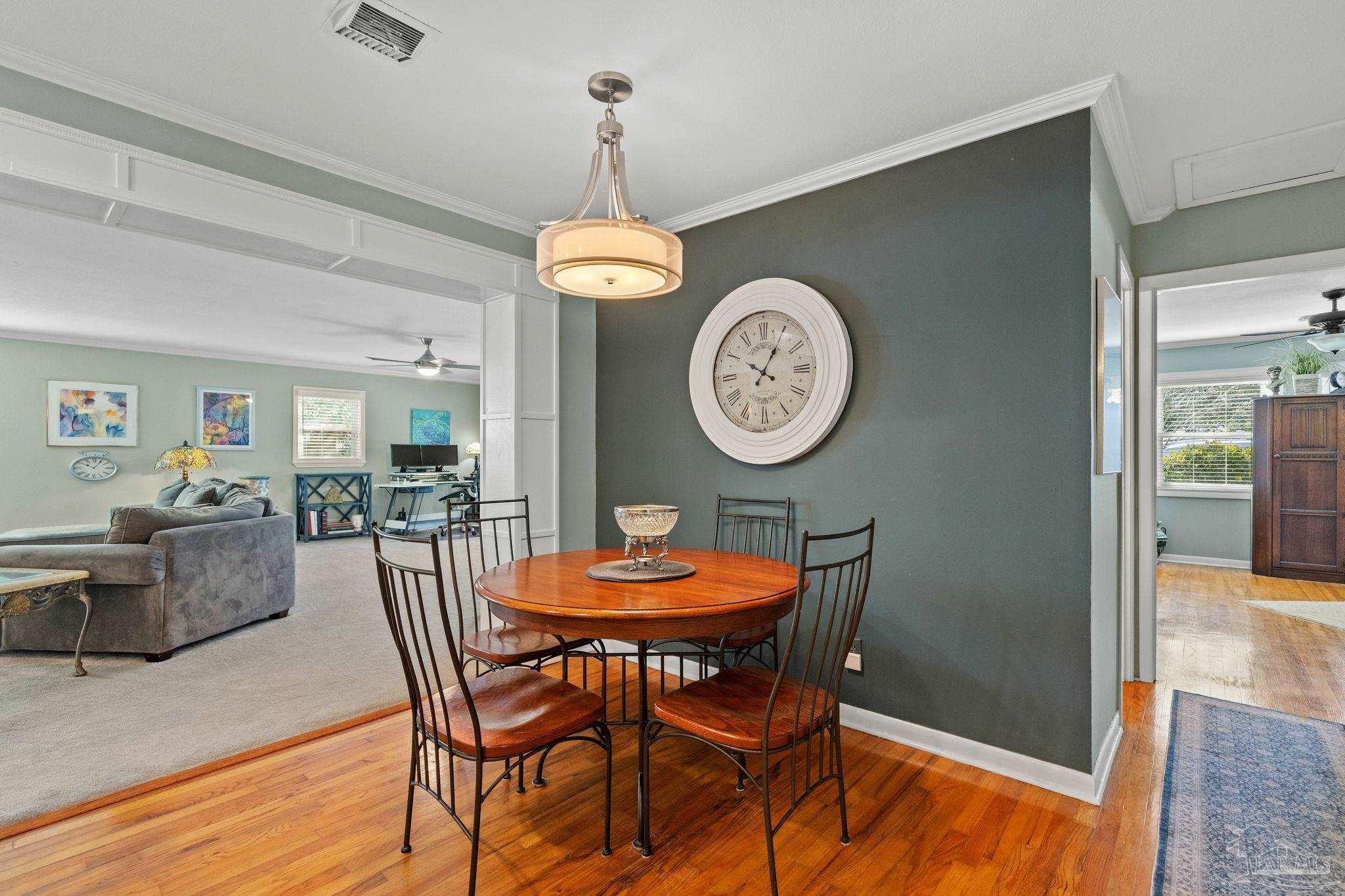 6001 Hilltop Road Pensacola, FL 32504 - Photo 11 of 37 a view of a dining room with furniture a chandelier and wooden floor