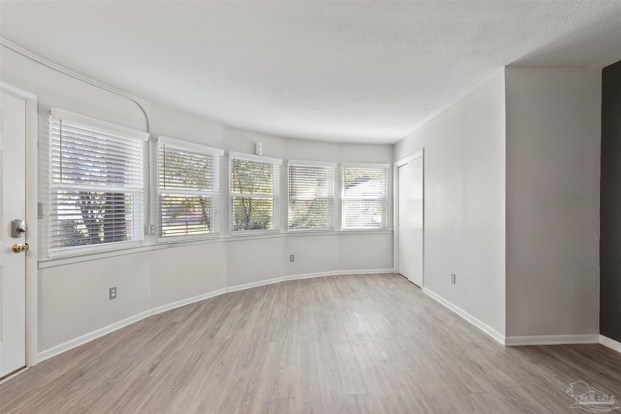 6001 Hilltop Road Pensacola, FL 32504 - Photo 31 of 37 an empty room with wooden floor and windows