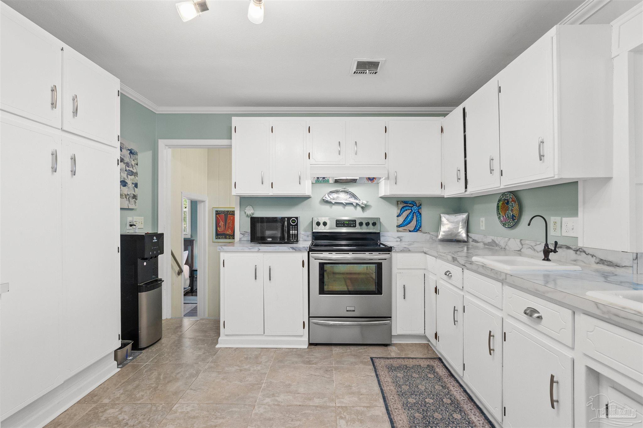 6001 Hilltop Road Pensacola, FL 32504 - Photo 9 of 37 a kitchen with granite countertop white cabinets and white appliances