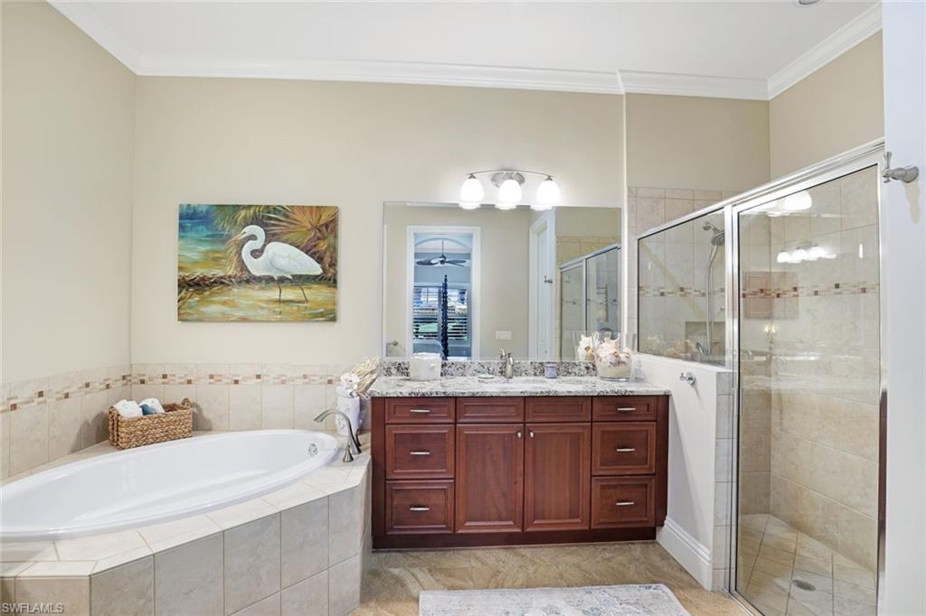 7599 Moorgate Point Way Naples, FL 34113 - Photo 24 of 38 a bathroom with a granite countertop sink a toilet a mirror and shower