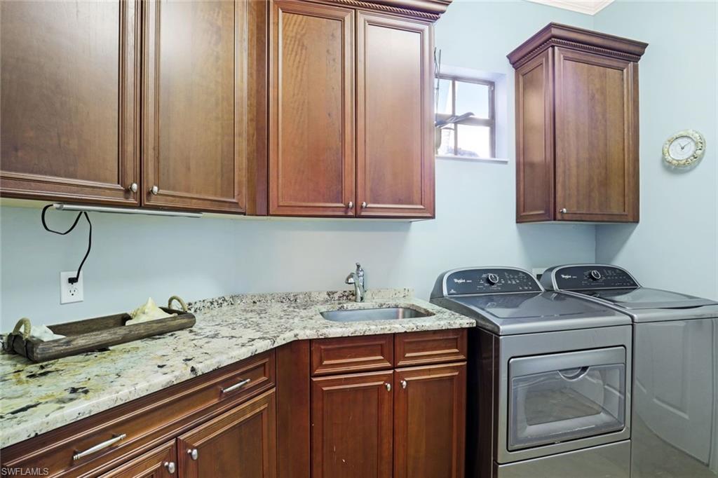 7599 Moorgate Point Way Naples, FL 34113 - Photo 28 of 38 a kitchen with granite countertop cabinets sink and wooden floor