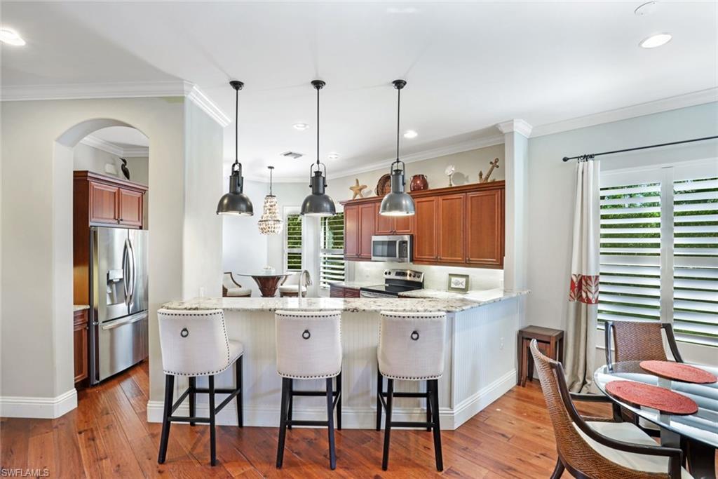 7599 Moorgate Point Way Naples, FL 34113 - Photo 3 of 38 a kitchen with stainless steel appliances kitchen island granite countertop a sink and cabinets