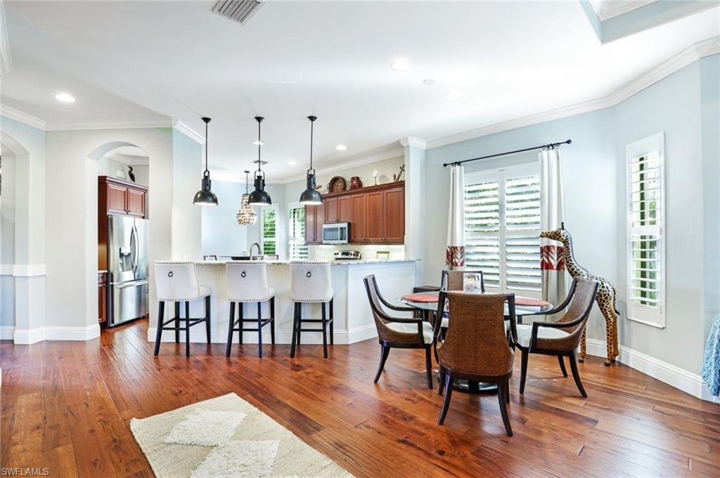 7599 Moorgate Point Way Naples, FL 34113 - Photo 8 of 38 a dining room with furniture wooden floor and a rug