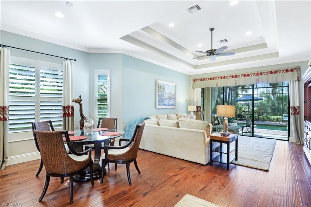 7599 Moorgate Point Way Naples, FL 34113 - Photo 10 of 38 a view of a dining room with furniture wooden floor and chandelier