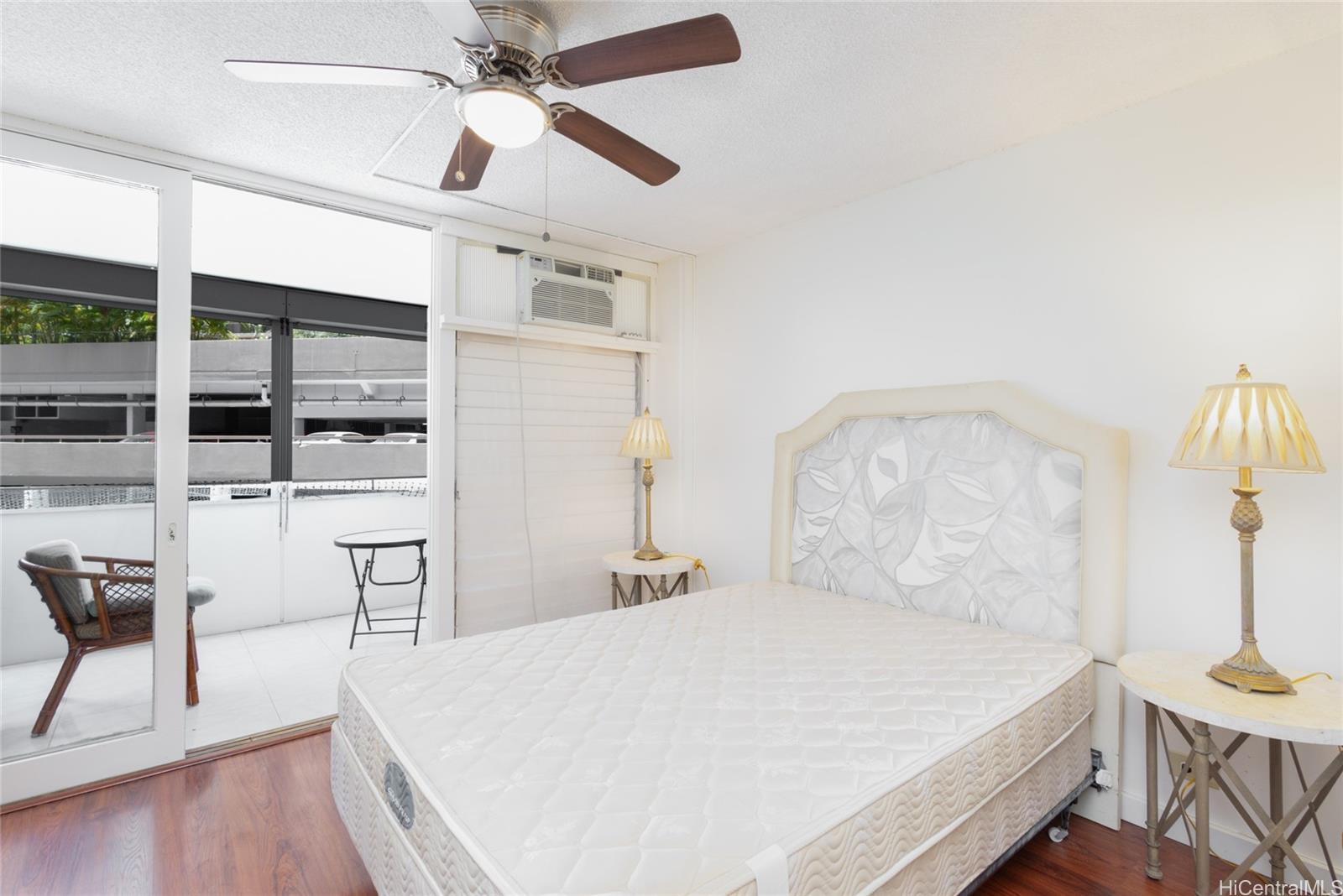 425 Ena Road, Unit 308C Honolulu, HI 96815 - Photo 5 of 10 a bedroom with a bed and a chandelier