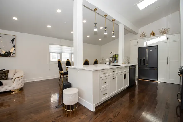 a kitchen with a sink appliances and wooden floor