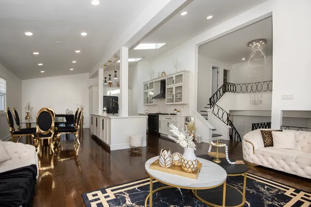 a living room with furniture kitchen view and a chandelier