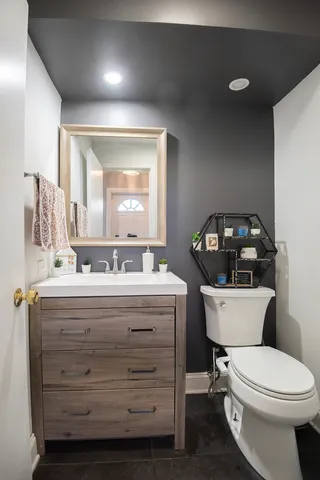 a bathroom with a toilet a sink and mirror
