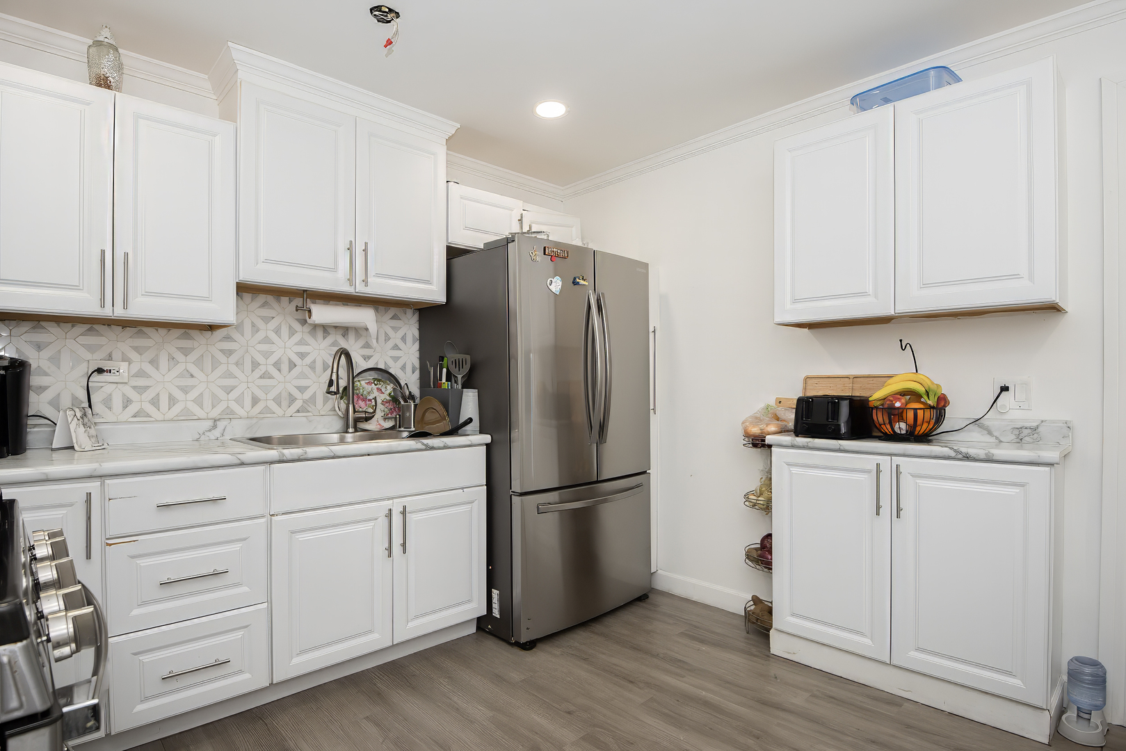 9909 North Huber Lane Niles, IL 60714 - Photo 32 of 36 a kitchen with granite countertop white cabinets and stainless steel appliances