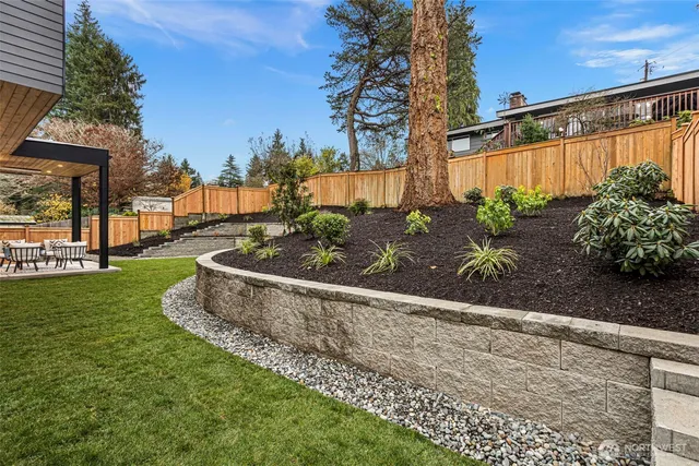 a view of a house with a yard and wooden fence