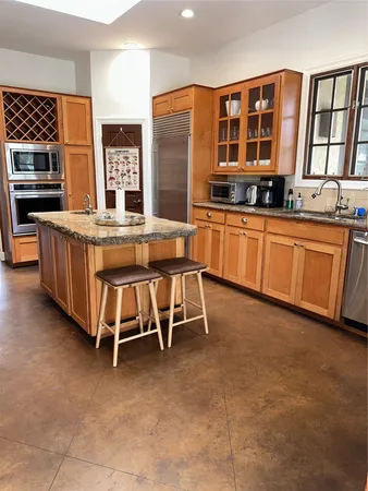 a kitchen with stainless steel appliances granite countertop a stove a sink and a refrigerator