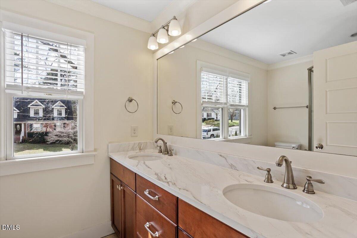 2718 Peachtree Street Raleigh, NC 27608 - Photo 24 of 38 a bathroom with a sink double vanity and a shower