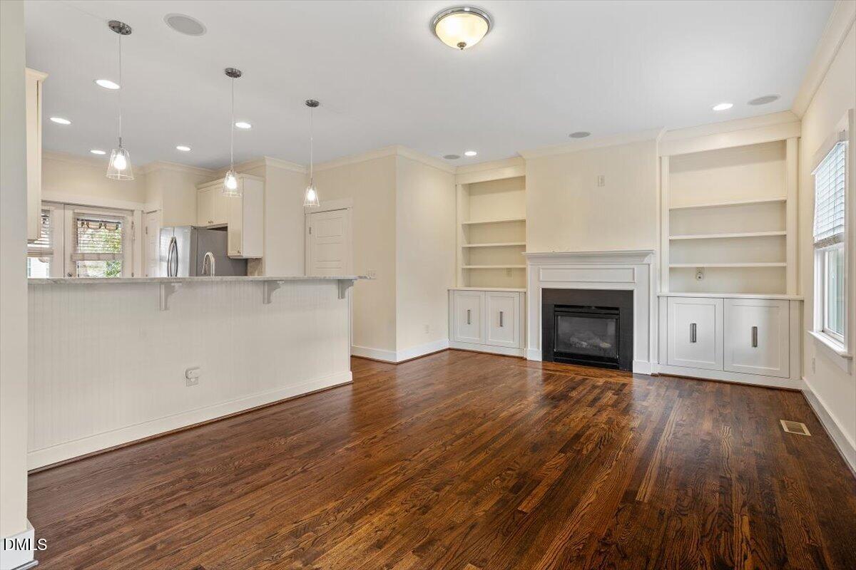 2718 Peachtree Street Raleigh, NC 27608 - Photo 10 of 38 an empty room with wooden floor and fireplace