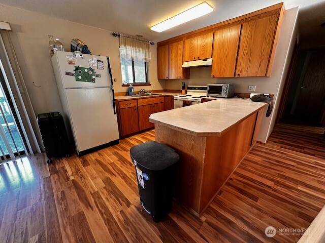 117 Squirrel Road Tonasket, WA 98855 - Photo 18 of 24 a kitchen with wooden floors sink appliances and cabinets