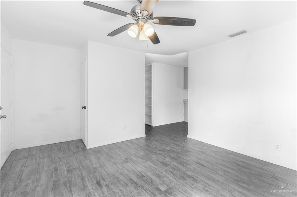 2311 Frontier Drive Palmview, TX 78574 - Photo 5 of 13 an empty room with wooden floor chandelier fan and closet in a room
