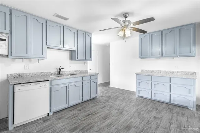 a kitchen with granite countertop a sink cabinets stainless steel appliances and a window