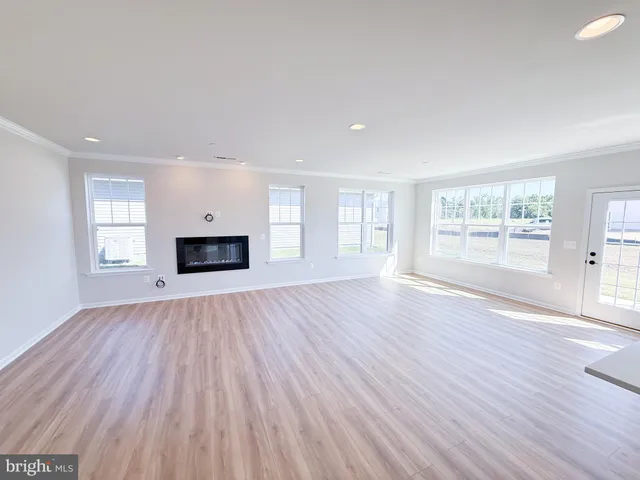 a view of empty room with wooden floor and fireplace