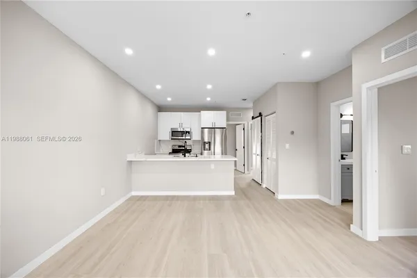 a view of a kitchen with a sink and wooden floor