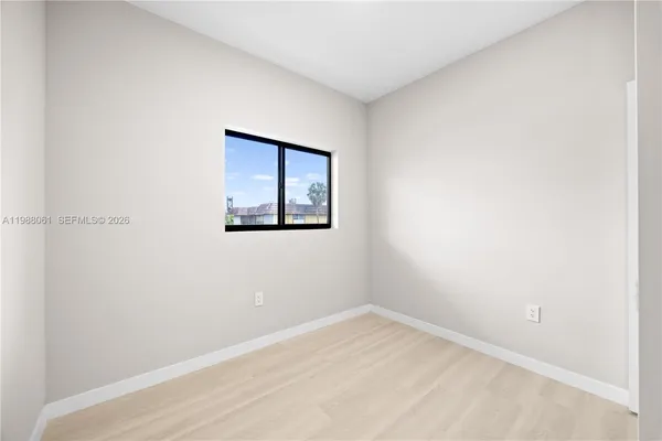 a view of empty room with wooden floor