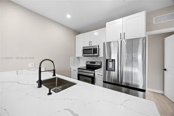 a kitchen with a refrigerator sink and stainless steel appliances