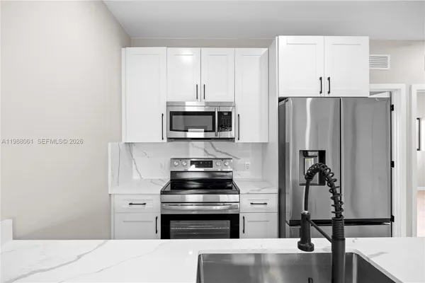 a kitchen with stainless steel appliances a refrigerator stove and microwave