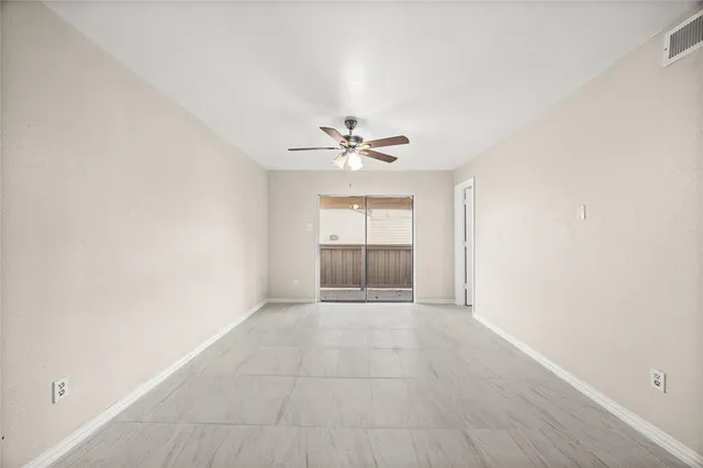 an empty room with fan and windows