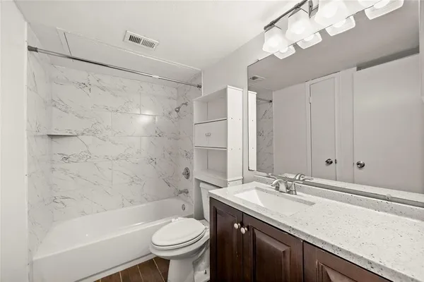 a bathroom with a sink a toilet a mirror a bathtub and shower