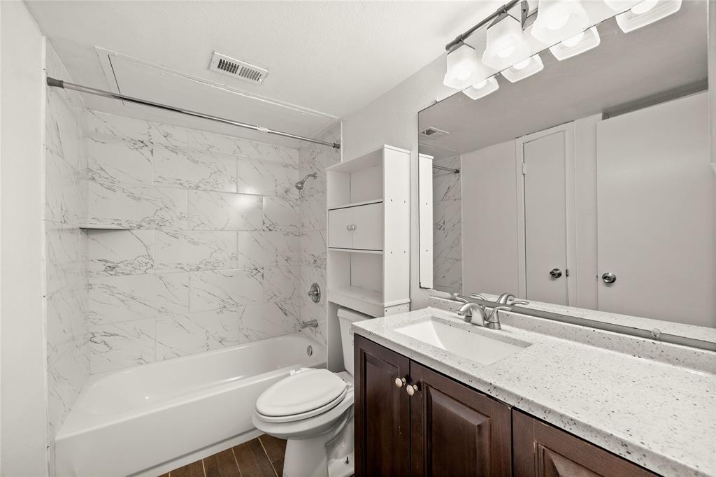 8110 Skillman Street, Unit 2053 Dallas, TX 75231 - Photo 7 of 12 a bathroom with a sink a toilet a mirror a bathtub and shower