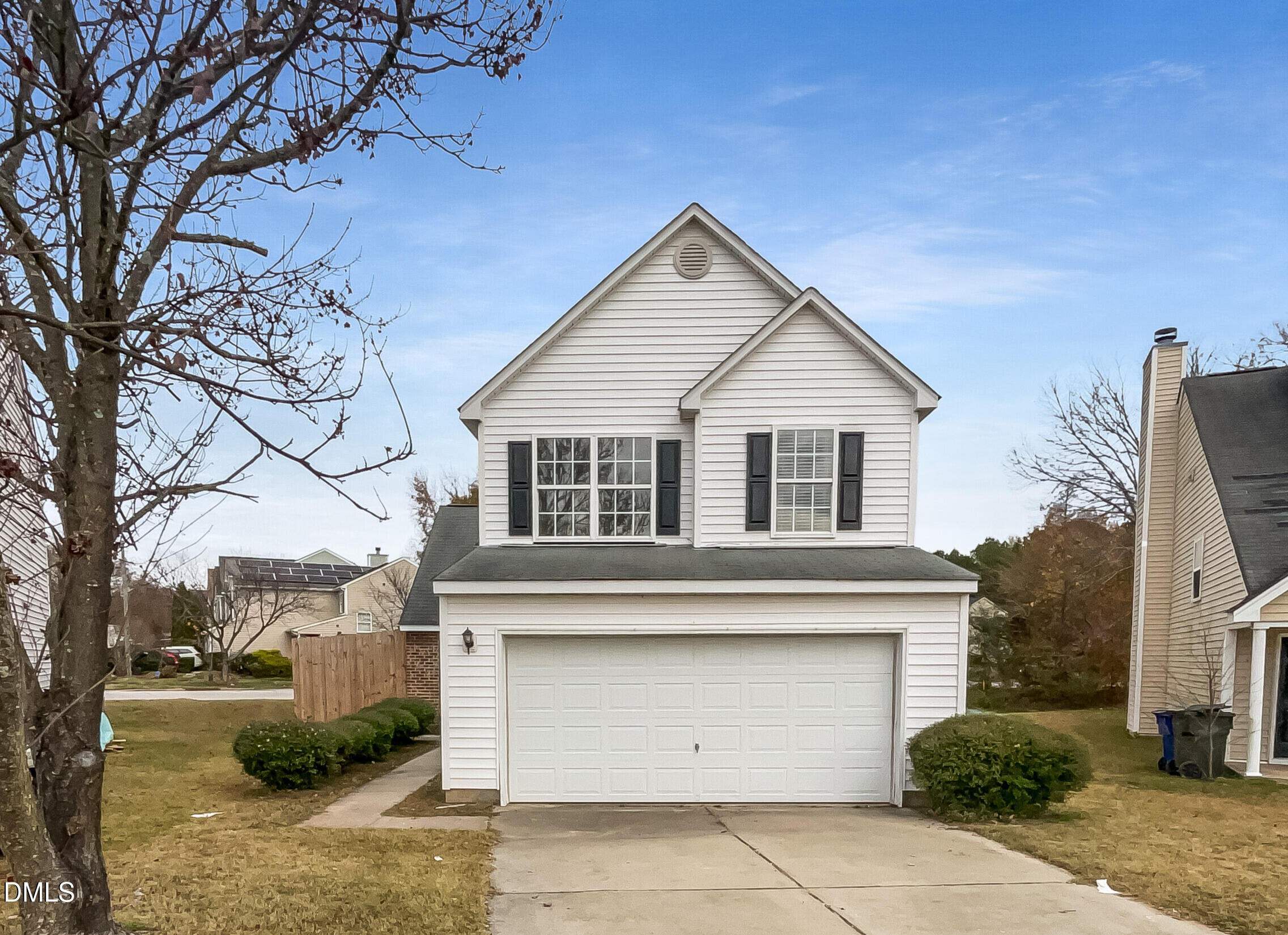 a view of a white house with a large tree
