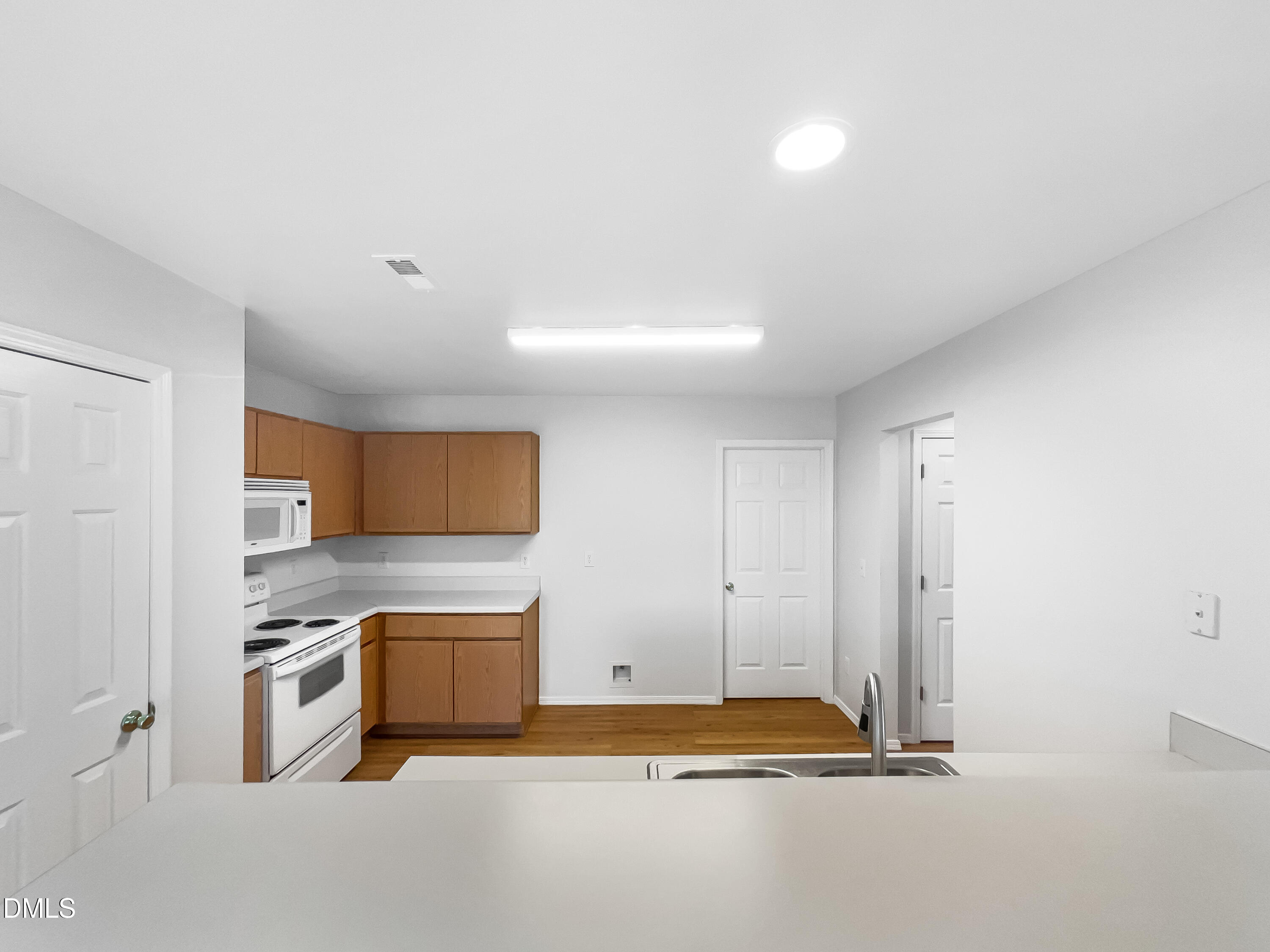 2504 Landale Court Raleigh, NC 27610 - Photo 6 of 16 a kitchen with granite countertop a sink and a stove top oven with wooden floor
