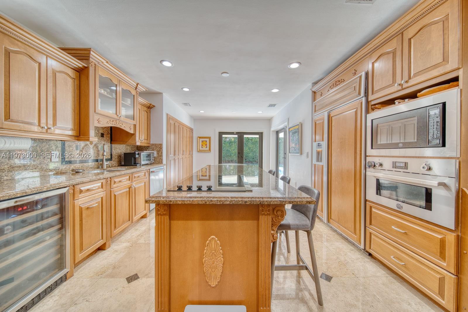 9220 Southwest 102nd Street Miami, FL 33176 - Photo 11 of 53 a kitchen with stainless steel appliances granite countertop a stove top oven a sink dishwasher a dining table and chairs with wooden floor