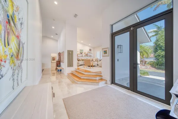 a living room with furniture a large window and wooden floor