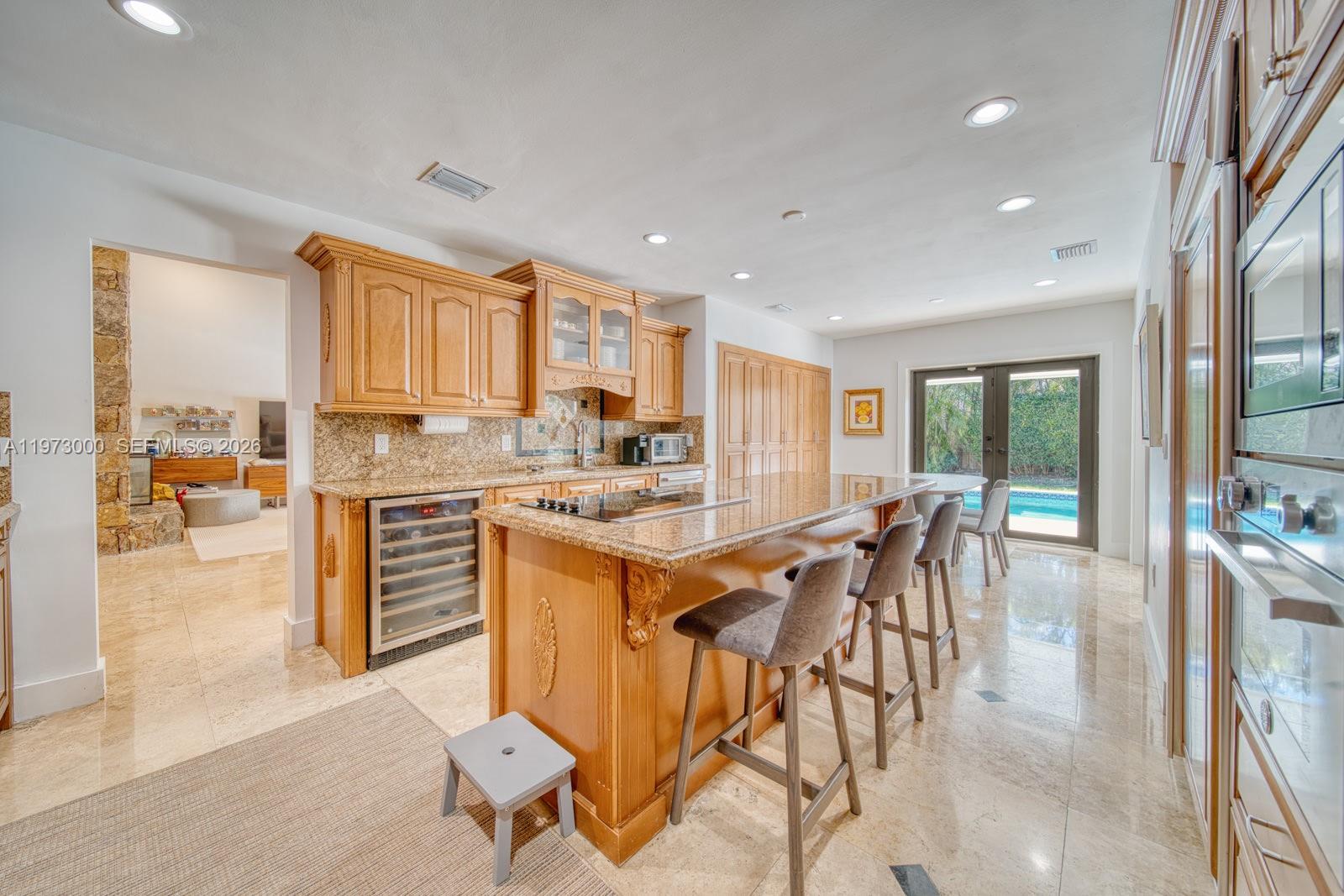 9220 Southwest 102nd Street Miami, FL 33176 - Photo 10 of 53 a kitchen with stainless steel appliances kitchen island granite countertop a table and chairs in it