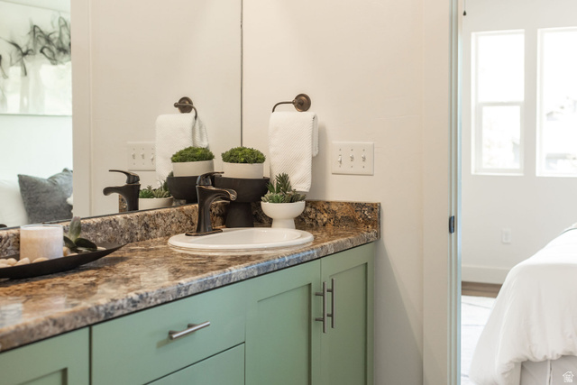 1552 Sumac Drive Logan, UT 84321 - Photo 26 of 72 Bathroom vanity featuring a drop-in sink, dark bronze faucet, and a stone-look countertop