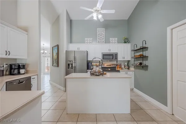a open kitchen with cabinets a refrigerator and a stove top oven