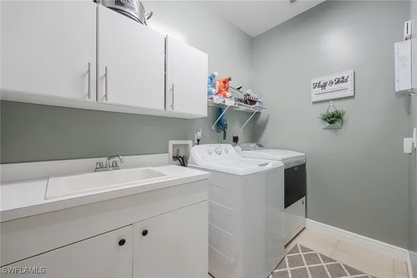 a utility room with sink dryer and washer