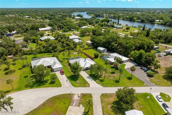 an aerial view of residential houses with outdoor space and trees