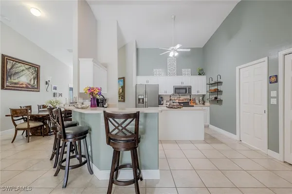 a kitchen with cabinets and chairs