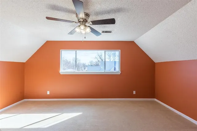 an empty room with a window and a ceiling fan