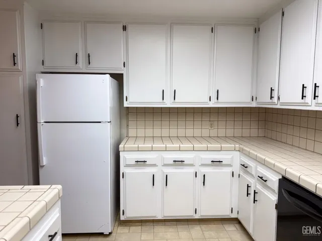 a kitchen with white cabinets and white appliances