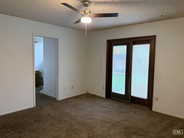an empty room with closet and a chandelier fan