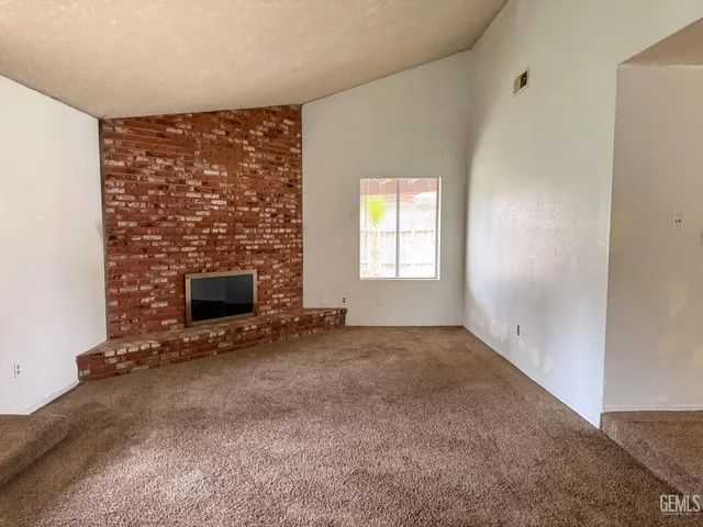 a view of empty room with a fireplace