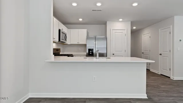 a view of kitchen with stainless steel appliances refrigerator sink and cabinets