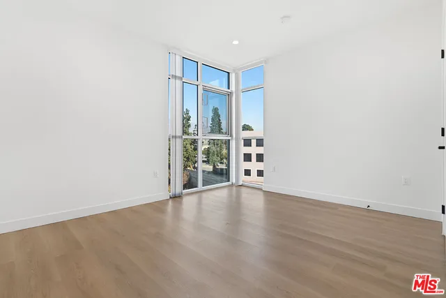 a view of an empty room with wooden floor