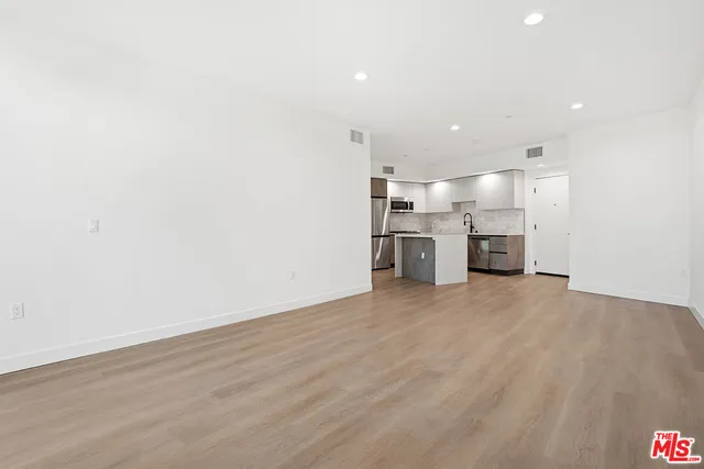 a view of a kitchen with a sink and a refrigerator