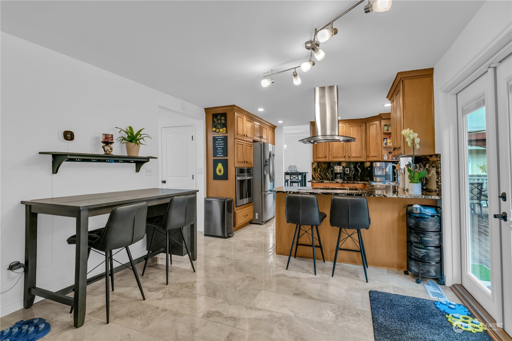1130 Southwest 354th Street Federal Way, WA 98023 - Photo 13 of 25 a kitchen with stainless steel appliances kitchen island granite countertop a table chairs and a refrigerator